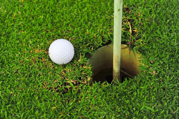 Golf ball on lip of cup — Stok fotoğraf