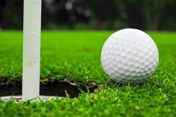 Golf ball on lip of cup — Stok fotoğraf