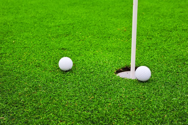 Dos pelotas de golf en campo de golf putting green —  Fotos de Stock