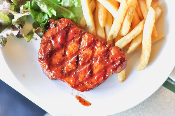 접시에 돼지고기 허리 고기 스테이크와 감자 튀김 봉사 — 스톡 사진