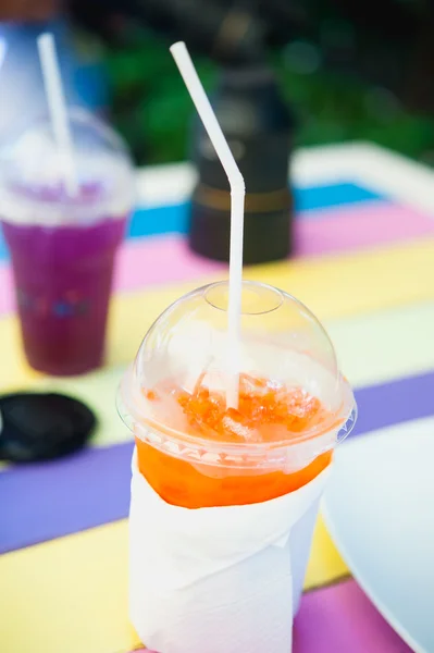 Tomar un vaso de jugo de naranja fresco en la colorida mesa de madera —  Fotos de Stock