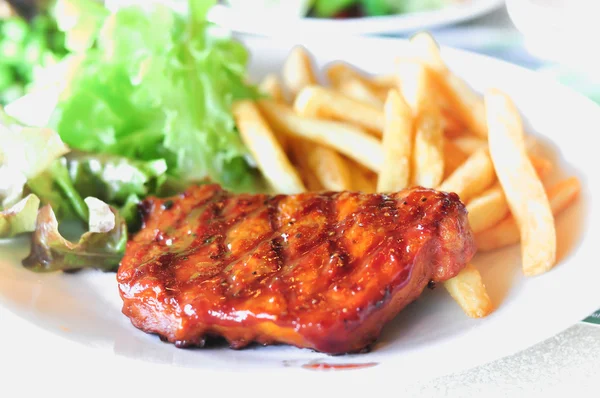 Steak de longe de porc dans un plat Servir avec des frites — Photo