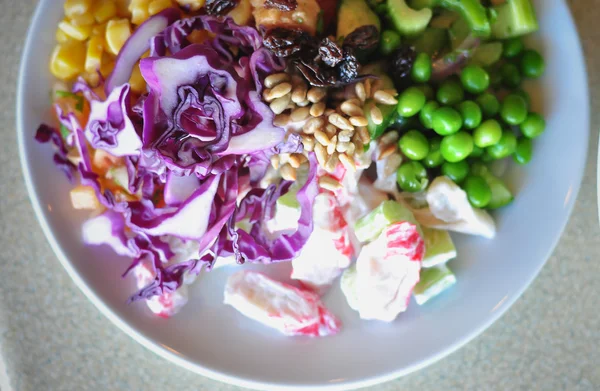 Färska grönsaker sallad på vit skiva, närbild — Stockfoto