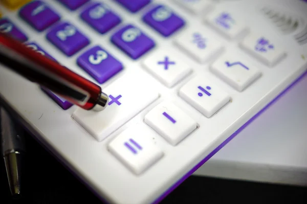 A lila számológép és a piros tollat. — Stock Fotó