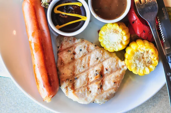 Pork steak with Sausage and vegetable salad on white dish — Stock Photo, Image