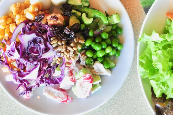 Färska grönsaker sallad på vit skiva, närbild — Stockfoto