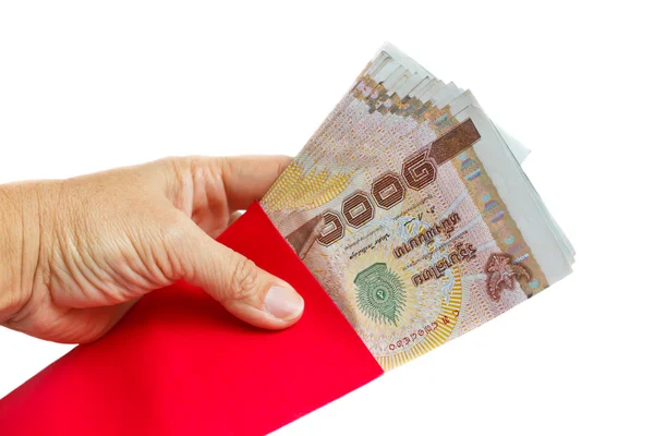 Рука держит красные конверты с деньгами . — стоковое фото