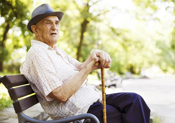 Senior man relaxing outdoors on a park early in the morning. — Stock Photo, Image