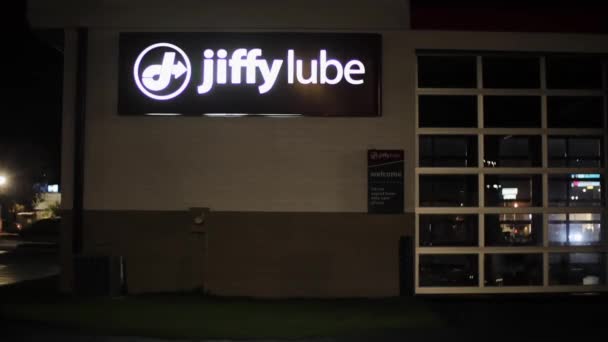 奥古斯塔 Usa Jiffy Lube机油更换零售店在夜间建筑标志和交通倒影 — 图库视频影像