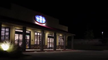 Augusta, Ga USA - 10-18-21: Modern bir çamaşırhanenin içindeki insanlar gece kapısından içeri bakıyorlar