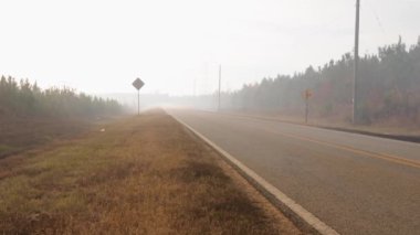 Burke County, Ga USA - 123: Orman yangını yoğun duman yol boyunca ilerliyor