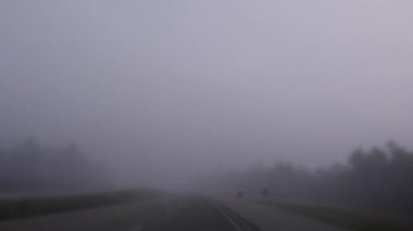Gürcistan 'ın kırsal kesimlerinde sisli bir sabahta kırsal bir otoyolda araba süren POV FPV