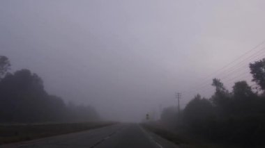 Gürcistan 'ın kırsal kesimlerinde sisli bir sabahta kırsal bir otoyolda araba süren POV FPV