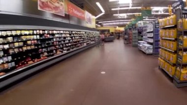 Augusta, Ga USA - 01 02 22: Walmart retail interior POV walking back aisle customer and workers wear face masks