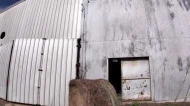 Burke County, Ga USA - 01 02 22: Pan of a old historic tin metal industrial building and puffy clouds with blue sky