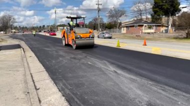 Augusta, Ga USA - 02-16-22: Yol kaldırım ekibi bir buhar silindirine ve trafiğe yakın çekim yapacak.