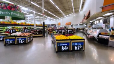 Grovetown, Ga USA - 05 13 22: Walmart Supercenter retail store front pan of produce and people 
