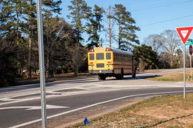 Augustam Ga USA - 05 10 22: Sarı okul otobüsü yolun gerisine doğru gidiyor