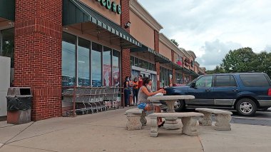 Doraville, Ga USA - 07 05: 20: Masada oturan telefon maskesi takan kadın