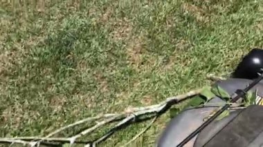 Tekerlek altında sopa olan bir çim biçme makinesi.