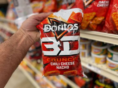 Grovetown, Ga USA - 07 24 22: Retail grocery store hand holding bag of Doritos 3D