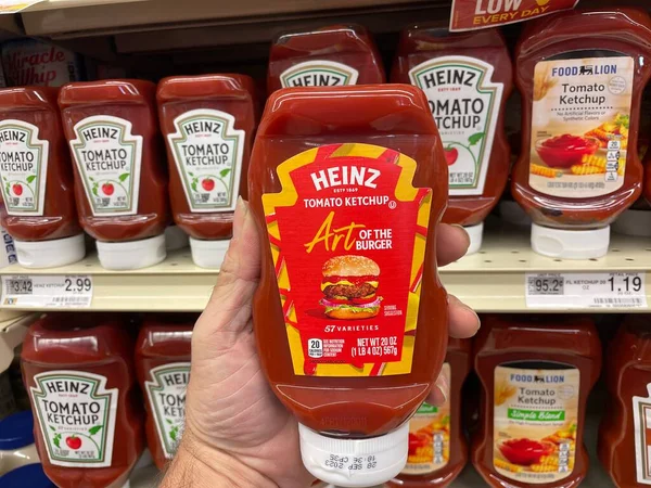 Grovetown, Ga USA - 07 24 22: Retail grocery store hand holding Heinz ART ketchup