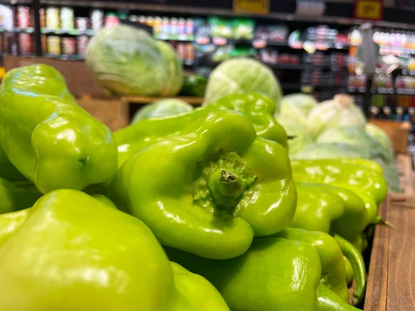 Grovetown, Ga USA - 06 10 22: Retail grocery store pile of green peppers on display
