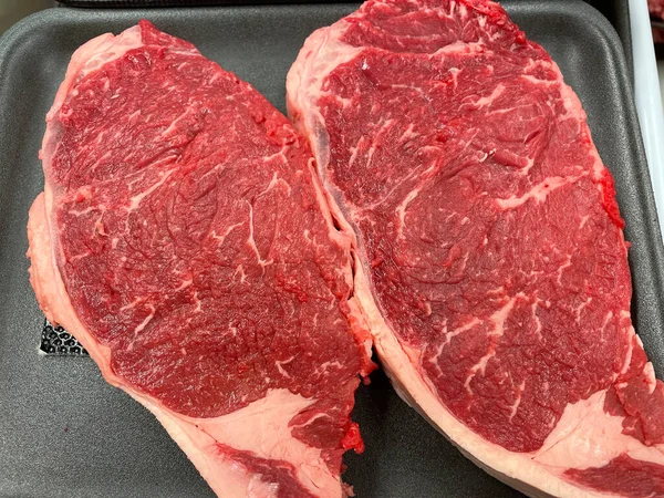 Two raw red New York strip steaks in a butcher shop Georgia USA
