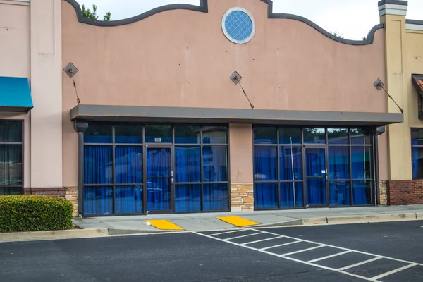 Retail strip mall store front with blue curtains in windows Georgia USA