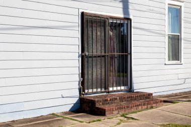 Old vintage historic white wooden building side door with bars Augusta Georgia USA