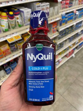 Grovetown, Ga USA - 10 08 22: Market NyQuil soğuk algınlığı ve grip ilacı el ele tutuşması