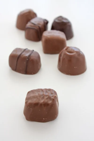 Düz beyaz arka plan üzerinde çikolatalar. — Stok fotoğraf