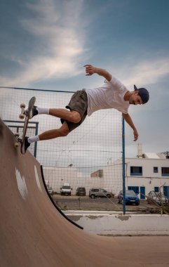 young man skateboarding on the ramp of a skate parkin Lanzarote. vertical composition