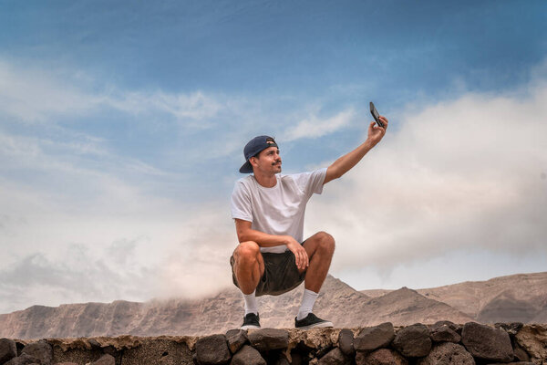 Молодой человек делает селфи на пляже Фамара. Лансароте. Канарские острова