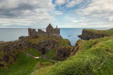 Bulutlu bir günde Kuzey İrlanda 'daki Dunluce Şatosu manzarası. Portreler. Birleşik Krallık