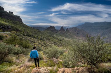 Genç adam, Büyük Kanarya 'nın tepesindeki manzaranın tadını çıkarıyor.