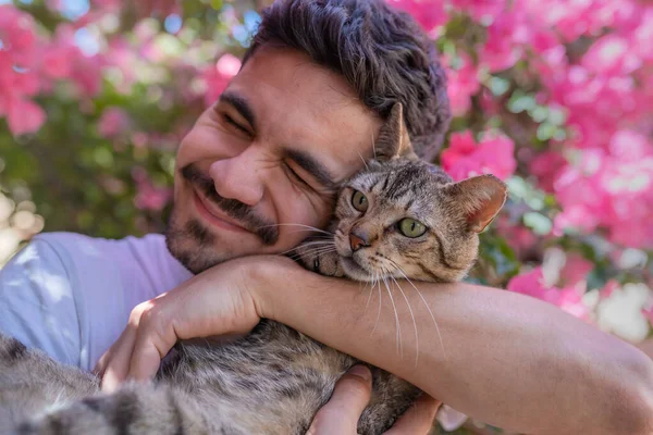 Nahaufnahme Junger Mann Umarmt Eine Grau Gestromte Katze Mit Grünen — Stockfoto