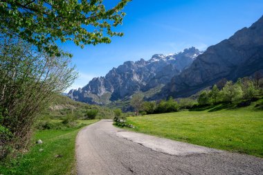 Arka planda Picos de Europa dağları olan Cain de Valden yolu. Len. İspanya