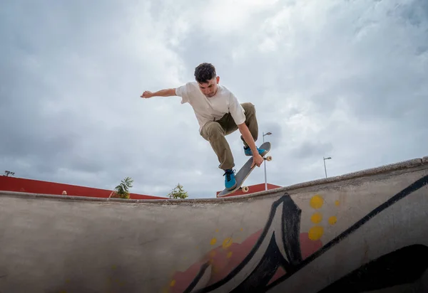 young skateboarder jumps over a bowl in a skate park