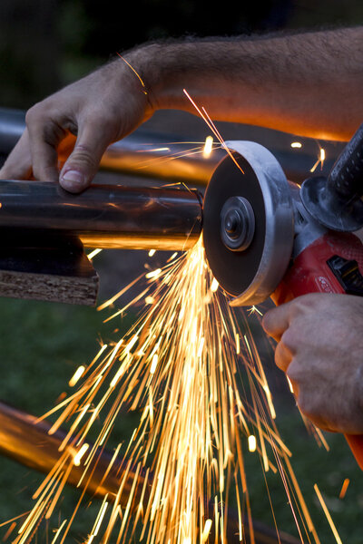 Man workin with iron, sparks