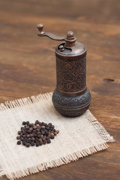 Vintage turkish pepper mill and black peppercorns — Stock Photo, Image