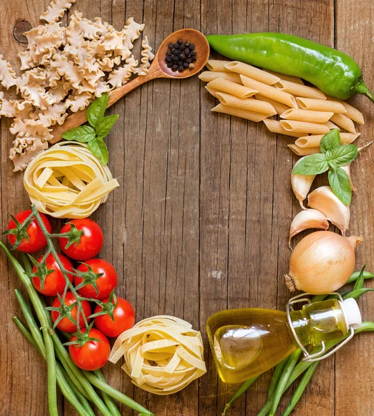 Pastas, verduras y hierbas sobre madera — Foto de Stock