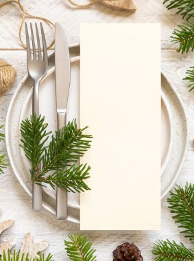 Tabaklar, çatal bıçak seti ve köknar ağacı dalları çok güzel görünüyor. Noel ya da yeni yıl menüsü beyaz ahşap masa, kopyalama alanı. Kış düğünü, restoran tatili yemekleri.