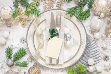 Gümüş ve altın renkli masa dekorları ve boş kart şablonlu köknar ağacı dalları. Beyaz mermer masa dairesi üzerinde noel ya da yeni yıl davetiye kartı, kopyalama alanı. Kış mevsimi, restoran tatili