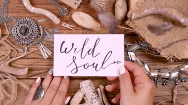 WILD SOUL kartı ile ahşap masa üstü görünümü üzerinde el  