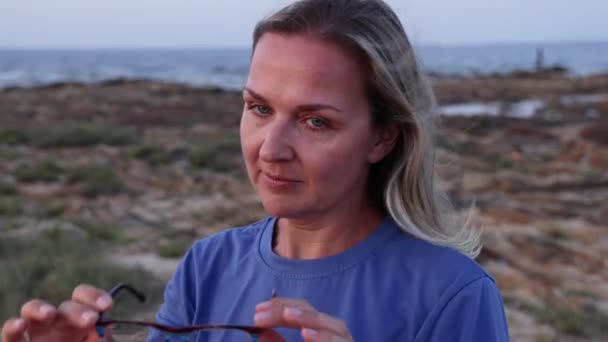Keski Ikäinen Blondi Nainen Laittaa Silmälasit Seisoo Lähellä Merta Auringonlaskun — kuvapankkivideo