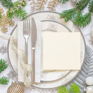 Süslü şenlik masası, köknar ağacı dalları ve kare kare boş kart manzaralı. Beyaz mermer masa dairesi üzerinde noel ya da yeni yıl davetiye kartı, kopyalama alanı. Kış mevsimi, restoran tatili