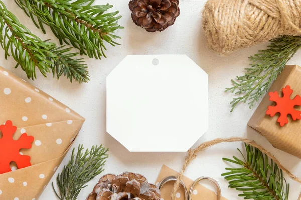 Karácsonyi Papír Ajándék Címke Egy Fehér Asztal Fenyő Ágak Csomagolt — Stock Fotó