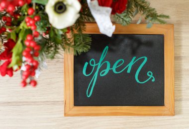 Noel tatilinde bir çiçekçi dükkanında açık yazı yazan küçük bir yazı tahtası