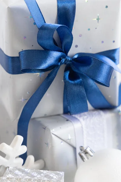 Завернутый Подарок Голубым Луком Белыми Голубыми Серебряными Рождественскими Украшениями Вокруг — стоковое фото